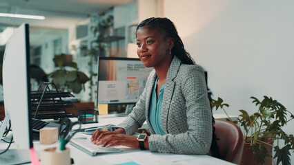 Business, typing and black woman in office, computer and smile with internet, fashion magazine and...