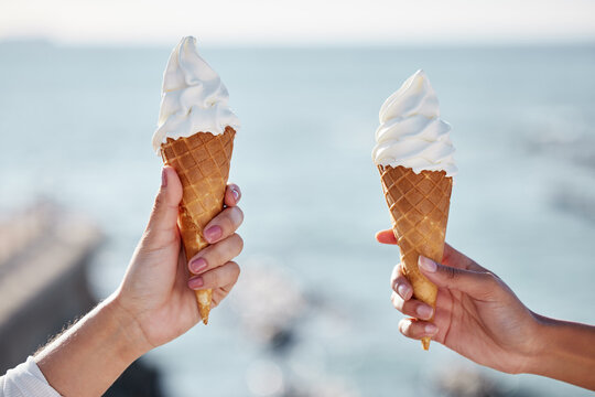 Women, ice cream and hands at a beach on summer holiday with dessert and sweet treat. Vanilla, friends and ocean with eating together on vacation in Miami with food in the sun with snack by the sea