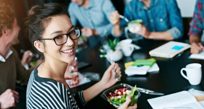 Business people, portrait and woman with salad, eating or healthy lunch with internship. Group, employee or coworkers in office, professional or nutrition with smile, organic food or meal for protein