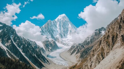 Majestic mountain peak, glacial valley, and cloudy sky.  Vast, snow-capped mountain range,  with a glacier flowing down a valley,  under a bright blue sky with fluffy clouds