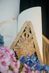 Close-up of traditional triangle wood carving with intricate floral patterns, surrounded by soft...
