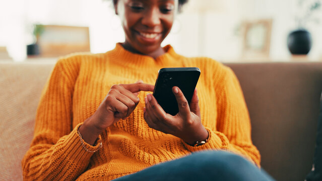 Hands, phone and texting on sofa in home, contact or relax with scroll on web chat in living room. Black woman, smartphone and click on mobile app for notification, happy or social network in house