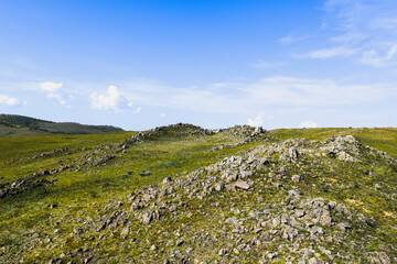 Khakassia. Old stone wall. Mountain landscape with blue sky