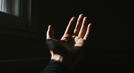 A Hand Reaching for Light: A Study in Shadows and Hope