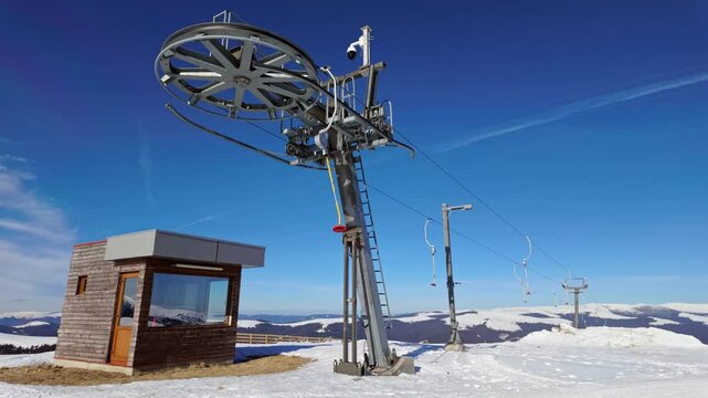 Empty button lift station return end at Transalpina ski resort on a sunny winter day in Romania.