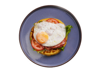 Fresh waffles with fried eggs, lettuce, tomatoes and served for breakfast on a white background.