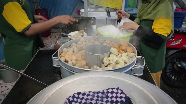  a pile of fresh asian streetfood called bakwan malang or bakso malang on a stall chart taken from high angle.