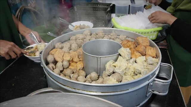  a pile of fresh asian streetfood called bakwan malang or bakso malang on a stall chart taken from high angle.