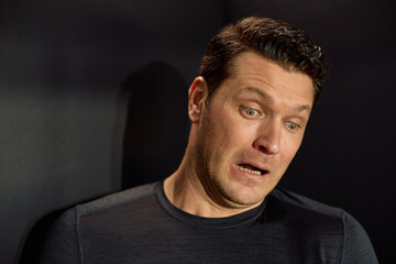 Studio shot of man feeling shocked after receiving bad news.