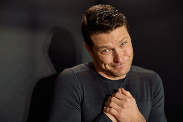 Remorseful man asking for forgiveness and looking at camera.