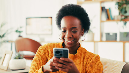 Black woman, phone and happy on sofa in home, texting and relax with web chat in living room....