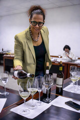 Sommelier pouring white wine during tasting session