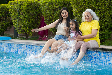 Summer Holiday Multi generation-Grandmother mother and granddaughter enjoy splashing water at...