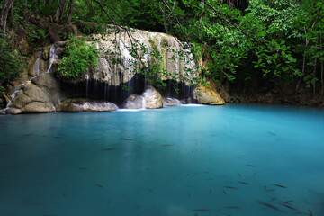 Naklejka premium Tropical landscape with beautiful waterfall, emerald lake and rocks in wild jungle forest. Erawan National park, Kanchanaburi, Thailand