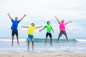 Four Children Joyfully Jumping On A Beach