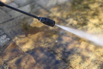 A terrace made of natural Travertine rock stone is cleaned with a high pressure cleaner which blasts the dirt off it.