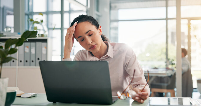 Woman, headache and stress with laptop at office for glitch, error and lost profit with burnout at finance agency. Person, accountant and frustrated with migraine, pain and brain fog with glasses