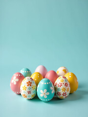 Fototapeta premium Easter Eggs In Vibrant Colors And Intricate Designs Are Carefully Arranged On A Pale Blue Tabletop Display.