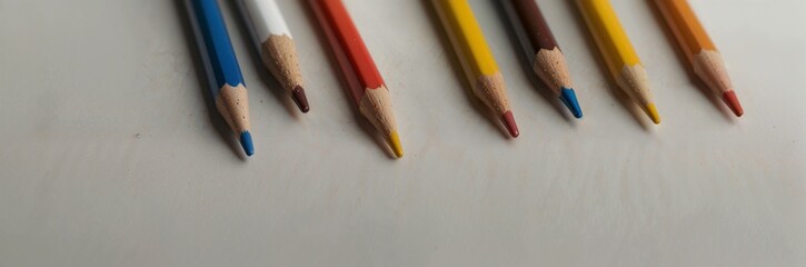 Colorful arrangement of colored pencils in various shades on a neutral background for copy space