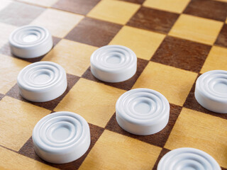 Checkers game setup on a checkered board. Strategy, game pieces, black and red, ready to play, board game.