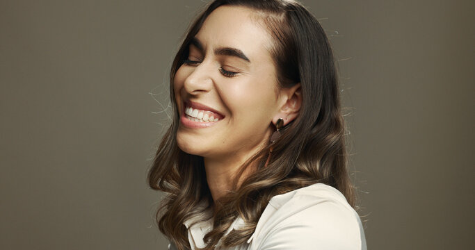 Laugh, comedy and woman in studio with smile, excited and happiness isolated on background with space. Face, funny and female model with eyes closed for goofy joke, comic humor and lol emotion for