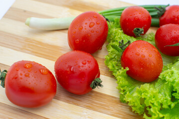 Seamless background featuring numerous fresh red tomatoes with green stems and water droplets. 