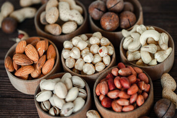 Assorted nuts for a background Almond, walnut,cashew, pistachios, hazelnuts, peanuts, Macadamia Collection of different varieties of nuts. Composition with dried fruits Healthy food. Organic