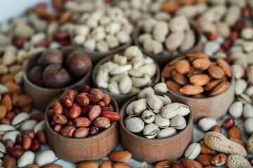 Assorted nuts for a background Almond, walnut,cashew, pistachios, hazelnuts, peanuts, Macadamia Collection of different varieties of nuts. Composition with dried fruits Healthy food. Organic