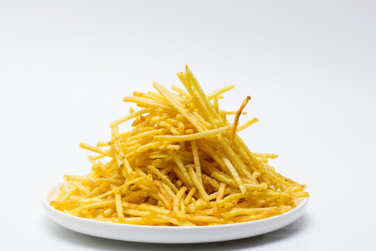 Plato de patatas fritas tipo paja con fondo blanco
