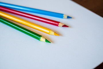colored pencils laud out on a blank white sheet of paper