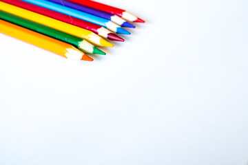 colored pencils laud out on a blank white sheet of paper