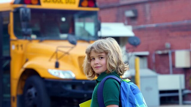 School kid waving hand near school bus. Child go to school bus. American education scene. School moment. USA childhood memory. Learning today. Child with sook and backpack ready to lesson.