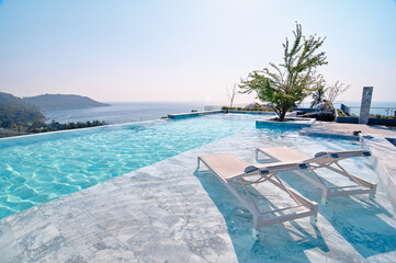 Infinity Pool Overlooking Scenic Ocean and Horizon with Relaxing Lounge Chairs..