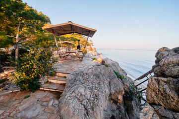 Seaside Stone Walkway with Covered Benches Overlooking the Ocean..
