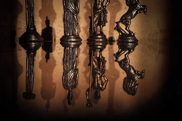 Miniature Roman figures and columns mirrored on a glossy surface, casting soft shadows and evoking...
