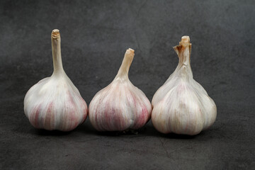 Obraz premium Fresh Garlic Bulb with Peeling Skins. purple garlic. Suitable for cooking, health, food introduction, nutrition topics.