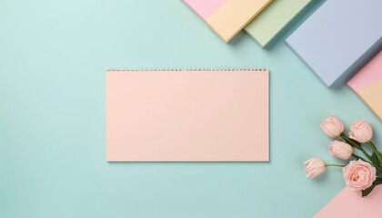 A spiral notebook, flowers, and blocks of paper are on a background.