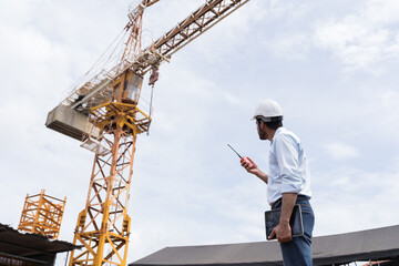 Man, Engineer, Construction site, Job site. Engineer construction worker controlling crane...