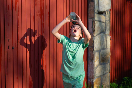 Sweaty boy drinking water from bottle after sport activity