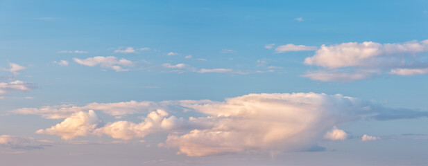 Panoramic background of evening sky with beautiful clouds, soft contrast and pastel colours