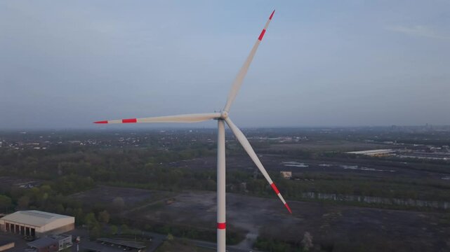 Windrad im Ruhrgebiet mit erkennbaren Energieerzeugern aus vergangenen Tagen im Hintergrund