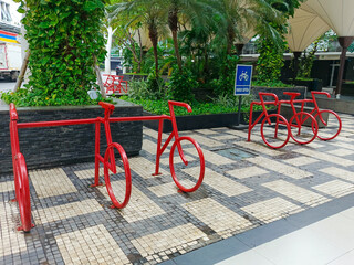 Stylish red bicycle racks on a tiled pavement. public facility