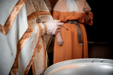 baptism or lighting of the water in the baptismal font, the priest consecrates the water by...