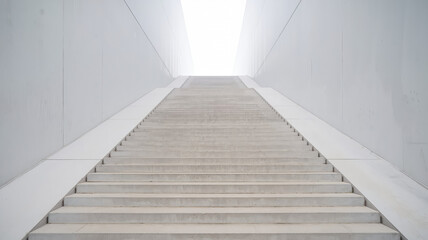 Fototapeta premium The modern concrete staircase ascends into a white, empty background, creating depth and perspective with a minimalist, clean design, free from distractions.