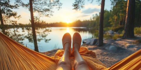 Woman relaxing in hammock by a tranquil lake during sunset, enjoying peaceful nature. Perfect for travel and relaxation imagery.