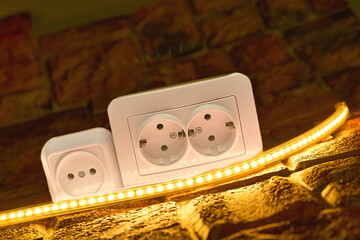 Two electrical sockets for connecting devices, glowing led strip