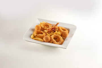 Assorted deep fried italian sicilian snack menu, onion rings, potatoes and olives on a white plate. Dish on a white background