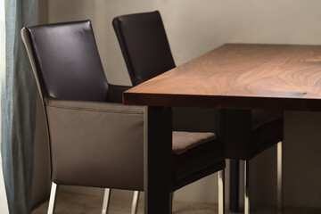 Minimalist kitchen interior with walnut dining table and leather arm chairs