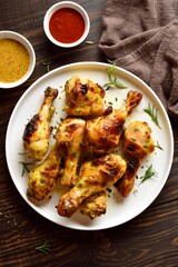 Barbecue roasted chicken drumsticks served with sauce