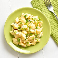 Potato salad with egg, pickle, green onion with mayonnaise and yogurt dressing, top view
